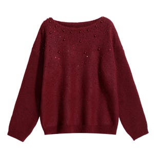 A burgundy-colored knitted sweater with small red beads or sequins scattered across the front.
