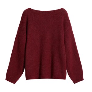 A burgundy-colored knitted sweater with long sleeves and a high neckline.