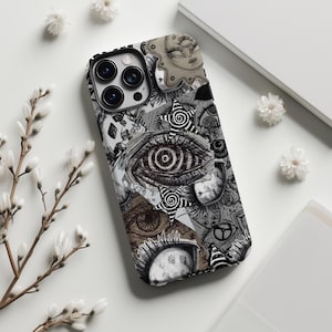 May include: A black and white phone case with a collage design featuring an eye, stars, and other abstract illustrations. The case is designed to fit a smartphone with multiple camera lenses.