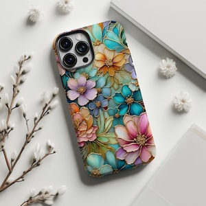 May include: A smartphone case with a vibrant floral pattern. The case showcases flowers in shades of pink, orange, blue, and purple, with gold detailing. The case is designed to fit a mobile phone.