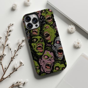May include: Black phone case with a repeating pattern of zombie faces in green, pink, and grey. The zombie faces have open mouths and exposed teeth. The case has a black border and camera cutouts.
