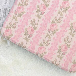 May include: A pink floral pattern featuring roses and leaves on a light pink background. The design has a textured appearance, with a repeating pattern of roses and leaves. The overall aesthetic is soft and feminine.