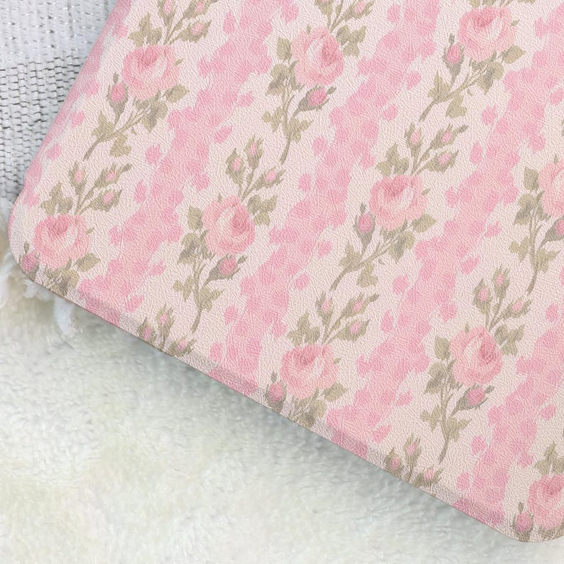 May include: A pink floral pattern featuring roses and leaves on a light pink background. The design has a textured appearance, with a repeating pattern of roses and leaves. The overall aesthetic is soft and feminine.
