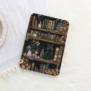 K&ouml;nnte beinhalten: Ein rechteckiges Dekotablett mit einer Illustration eines B&uuml;cherregals voller B&uuml;cher, Flaschen und Kristalle. Eine schwarze Katze sitzt auf einem Regal. Die Farbpalette umfasst Braun-, Gr&uuml;n- und Goldt&ouml;ne.