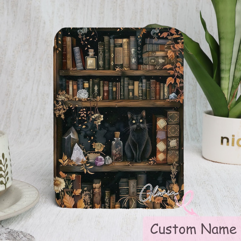K&ouml;nnte beinhalten: Dekoratives Panel mit einer Illustration eines B&uuml;cherregals voller alter B&uuml;cher, Flaschen und Kristalle. Eine schwarze Katze sitzt auf einem Regal. Die Worte "Custom Name" erscheinen unten.