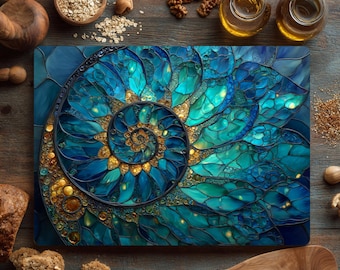 May include: Rectangular cutting board with a stained glass design featuring a nautilus shell in shades of teal, turquoise, and gold. The board is surrounded by wooden bowls, walnuts, and oil bottles on a wooden surface.