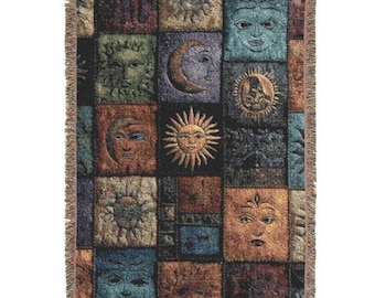 May include: Woven throw blanket featuring a patchwork design of celestial faces, including suns, moons, and human-like visages. The squares are in shades of blue, brown, green, and gold, with a fringed edge. The blanket is a decorative home textile.