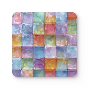 May include: Square coaster featuring a colorful mosaic design. The mosaic is composed of numerous small, square blocks in shades of pink, orange, yellow, green, blue, and purple. The coaster has rounded corners and a white background.