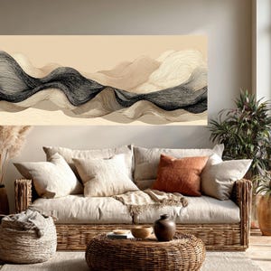 May include: A large abstract art piece with a beige background and black and beige wavy lines hangs above a wicker sofa with beige cushions and an orange pillow. A round wicker coffee table and a potted plant complete the living room scene.