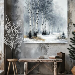 Könnte beinhalten: Ein gerahmter Leinwanddruck, der eine Winterwaldszene darstellt. Das Kunstwerk zeigt hohe Birken mit weißer Rinde und schwarzen Markierungen vor einer verschneiten Landschaft. Die Farbpalette besteht hauptsächlich aus kühlen Tönen von Grau, Weiß und gedämpftem Braun.