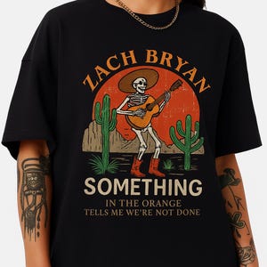 Zach Bryan etwas im orangefarbenen Skelett Cowboy T-Shirt Country Folk Music Lyric Merch Konzert Fan Tee