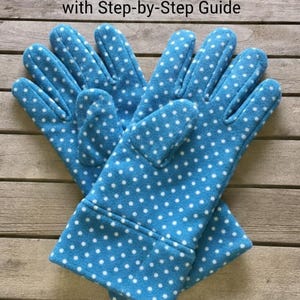 May include: A pair of blue fleece gloves with white polka dots. The gloves are on a wooden surface. Text at the top reads "Fleece Gloves Sewing Pattern with Step-by-Step Guide."