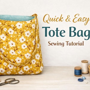 Puede incluir: Un bolso tote amarillo con un estampado floral blanco y correas marrones. La bolsa está junto a suministros de costura, incluyendo carretes de hilo, tijeras y tela. El texto en la imagen dice "Quick & Easy Tote Bag Sewing Tutorial."