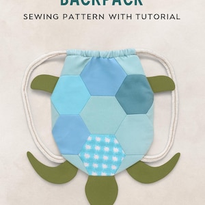 Könnte beinhalten: Ein schnürbarer Rucksack in Schildkrötenform mit einem Patchwork-Design in Blautönen und einem weißen Punktmuster. Der Rucksack hat grüne flossenartige Seitenteile und einen Kordelzugverschluss. Der Text oben lautet "TURTLE DRAWSTRING BACKPACK".