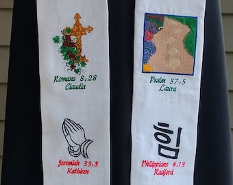 Könnte beinhalten: Weiße Stoffstola mit gestickten religiösen Versen und Namen. Die Stola hat einen goldenen Fransenbesatz und ist mit Bildern eines Kreuzes, einer Taube, einer Lampe und eines Herzens verziert.