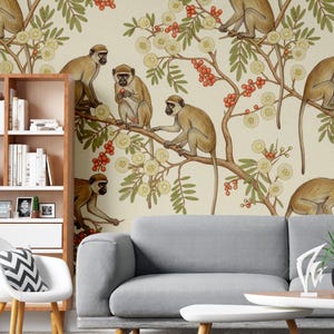 Puede incluir: Papel pintado con un patrón repetido de monos en ramas con flores y bayas. Los monos son marrones y beige, con follaje verde y amarillo. El fondo es de color beige claro. Tema botánico y natural.