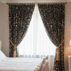 May include: Two dark mushroom-patterned curtains with gold tiebacks and tassels. The curtains are drawn back to reveal a sheer white curtain behind them. The mushroom pattern includes red, brown, and white mushrooms on a dark background.