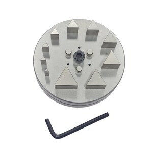 Pode incluir: Uma ferramenta de joalheria de metal prateado com várias formas triangulares e retangulares dispostas em uma base circular. Inclui uma chave hexagonal preta. A ferramenta é projetada para trabalhos de precisão.