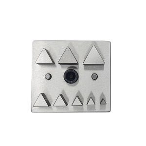 Pode incluir: Uma ferramenta quadrada de metal escovado para fazer joias com uma variedade de formas triangulares e um componente central preto. Dois pequenos orifícios circulares estão em ambos os lados do componente central.