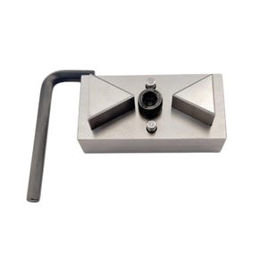 Pode incluir: Uma ferramenta de metal prateado com uma base retangular, duas peças triangulares e um componente central circular. Uma pega em forma de L, cinzenta escura, está presa. A ferramenta foi concebida para trabalhos de precisão.