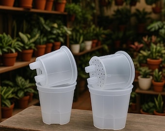 Może przedstawiać: Cztery przezroczyste plastikowe doniczki ułożone na drewnianej powierzchni. Doniczki mają cylindryczny kształt z lekko rozszerzonym brzegiem i otworami drenażowymi. Tło przedstawia półki wypełnione roślinami w doniczkach.