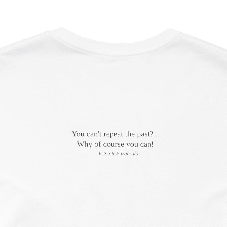 K&ouml;nnte beinhalten: Wei&szlig;es T-Shirt mit dem Zitat "You can't repeat the past?... Why of course you can!" von F. Scott Fitzgerald. Der Text ist in einer einfachen Schriftart gehalten und mittig auf dem Shirt platziert.