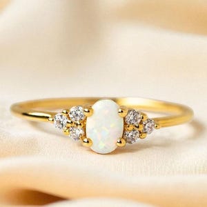 Anillo de compromiso de ópalo blanco de corte ovalado con detalles de diamantes en oro de 14 quilates. Delicado anillo de promesa con piedra natal de octubre.