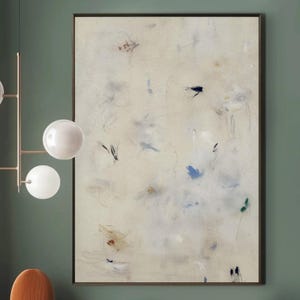 May include: An interior design scene featuring a mid-century modern style. A large abstract painting hangs above a wooden cabinet. An orange velvet armchair and a small chair with a wooden seat are in the foreground. A gold chandelier with four white globe lights hangs from the ceiling.