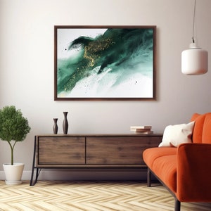 May include: Abstract painting with a green and gold color scheme. The painting is framed in a dark wood frame and is hanging on a white wall above a wooden dresser.