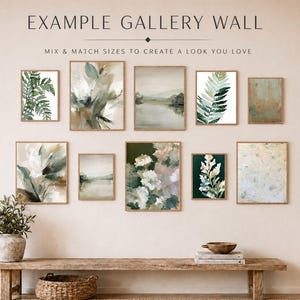a gallery wall with nine framed artworks of varying sizes and styles, arranged in a visually appealing manner. The artworks include abstract paintings, landscapes, and botanical prints, creating a diverse and harmonious display.