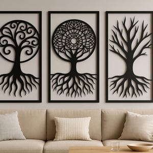 May include: Three black framed wall art pieces with tree designs. The art includes a tree with swirling branches, a tree with a circular mandala design, and a tree with bare branches. The art is displayed above a beige sofa.
