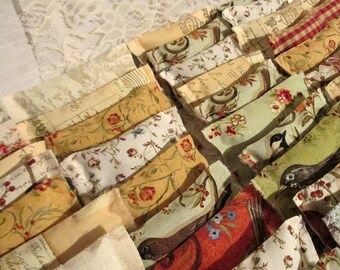 May include: A collection of fabric squares with various floral and bird patterns. The squares are sewn together to create a patchwork design. The fabric is in shades of brown, green, white, and red.