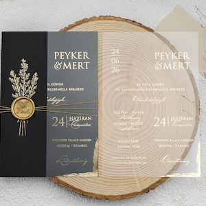 Puede incluir: Elegante conjunto de invitaciones de boda con una tarjeta negra y gris, detalles dorados y una superposición transparente. La invitación incluye los nombres "Peyker & Mert" y la fecha "24 Haziran".