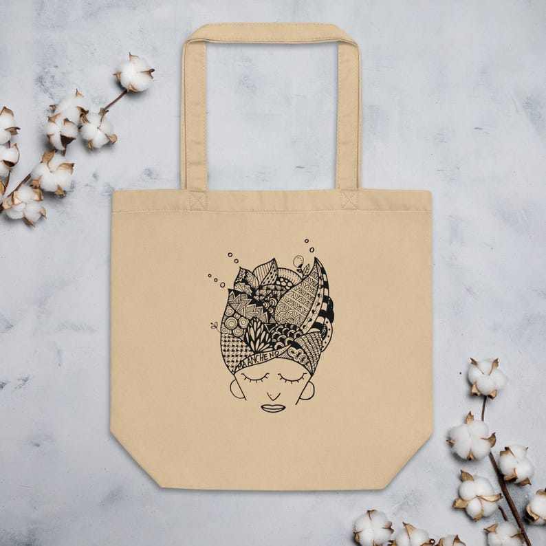 Pu&ograve; includere: Borsa tote beige con un'illustrazione in bianco e nero di un volto con gli occhi chiusi e un'acconciatura dettagliata. L'acconciatura &egrave; piena di vari motivi e forme. La borsa ha due manici ed &egrave; realizzata in tela.