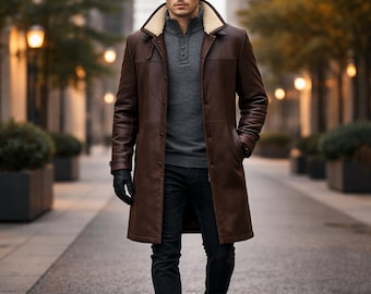 May include: A long brown leather coat with a cream-colored shearling collar, worn over a grey button-up sweater and dark trousers. The outfit includes black leather gloves and brown leather boots, creating a layered look.