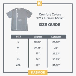 Może przedstawiać: Tabela rozmiar&oacute;w koszulki Comfort Colors 1717 z ilustracją szarego t-shirtu oraz strzałkami wskazującymi długość i szerokość. Tabela zawiera rozmiary od S do 2XL wraz z odpowiednimi wymiarami w calach. Widoczna jest nazwa marki KASMOE.