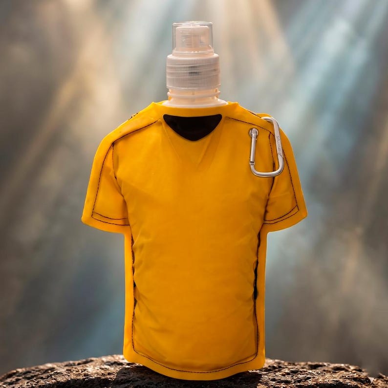 May include: A yellow water bottle shaped like a soccer jersey, with a white cap and a silver carabiner clip. The jersey has black trim and a black collar. The bottle is on a dark, textured surface.