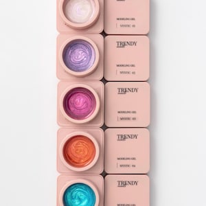 May include: Five square, light pink containers of Trendy Nails Modeling Gel, labeled Mystic 01 through 05. Each container features a circular opening revealing shimmering gel in white, purple, magenta, orange, and bright blue colors.