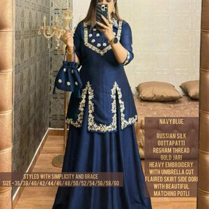 Peut inclure: Une tunique bleu marine à manches longues avec broderies dorées et une jupe évasée assortie. La tunique présente un col et un ourlet avant fendu. Une petite pochette à cordon assortie est incluse. Le texte indique soie russe, Gota Patti, fil Resham, zari doré et tailles 36 à 60.