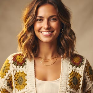 Könnte beinhalten: Eine Häkelstrickjacke mit einem Muster aus quadratischen Motiven in Senfgelb, Olivgrün und Creme. Das Kleidungsstück hat einen gerippten, cremefarbenen Rand entlang der Vorderöffnung und wird über einem schlichten, cremefarbenen Ripp-Top getragen.