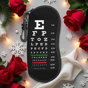 Op de afbeelding: Zwarte bagagelabel met een oogtestontwerp met letters zoals E, F, P en Z. De tag wordt omringd door rode rozen, decoratieve sneeuwvlokken en lichtslingers.