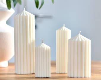 Candele a colonna fatte a mano con cera di soia biologica, disponibili in varie dimensioni e colori.