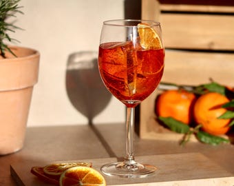 Handgemaakte Aperol Spritz-kaars met sinaasappelgeur, een realistische cocktailkaars.