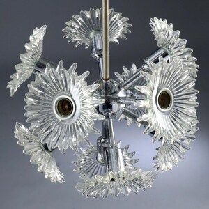 Puede incluir: Un candelabro vintage de estilo moderno de mediados de siglo. La l&aacute;mpara esf&eacute;rica presenta m&uacute;ltiples pantallas en forma de flor de vidrio transparente unidas a un marco de metal cromado. La l&aacute;mpara est&aacute; suspendida de una varilla central.