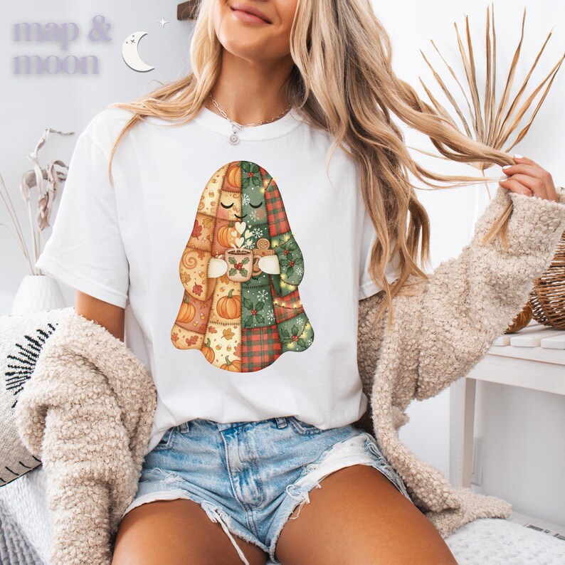 May include: White t-shirt featuring a patchwork ghost design holding a mug with a heart-shaped steam. The ghost is composed of autumn-themed patterns, including pumpkins and plaid. The text "map & moon" is in the upper left corner.