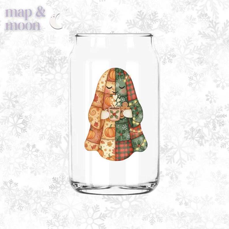 May include: A clear glass can-shaped drinking glass with a colorful illustration of a ghost holding a mug of hot cocoa. The ghost is made of patchwork with fall-themed patterns, including pumpkins and plaid. The glass has the words "map & moon" in the upper left corner.