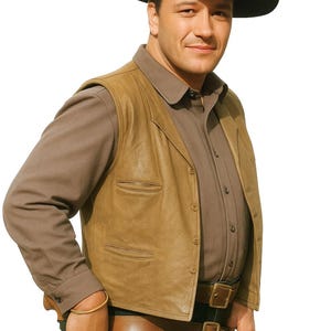 May include: A man wearing a black cowboy hat, brown button-up shirt, and a tan leather vest. He is also wearing a brown belt with two buckles. The man is holding a brown object.