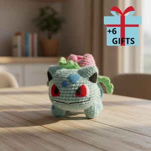 May include: A crocheted Bulbasaur plush toy in light blue, with red eyes, blue spots, and a pink and green flower on its back. The image includes a gift box graphic with the text "+6 GIFTS".