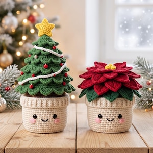 May include: Two crocheted amigurumi plants in cream-colored pots with embroidered smiling faces and pink cheeks. One is a green Christmas tree topped with a yellow star, white garland, and red beads. The other is a red poinsettia with green leaves.