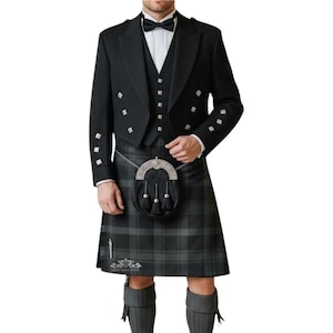Puede incluir: Un traje de kilt negro formal con chaqueta, chaleco y pajarita a juego. El kilt es de cuadros grises y negros, combinado con calcetines altos grises y un sporran negro. Detalles plateados adornan la chaqueta.